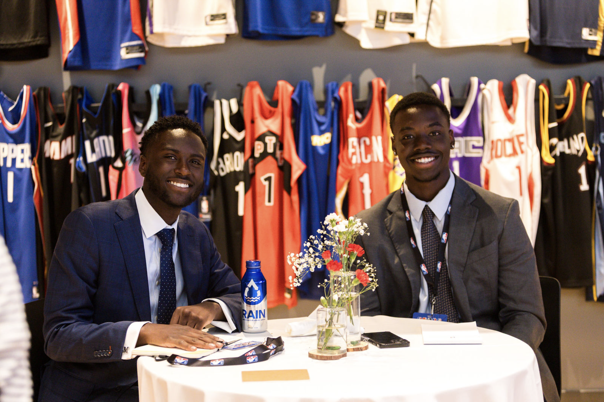 two men sitting at a table at an event